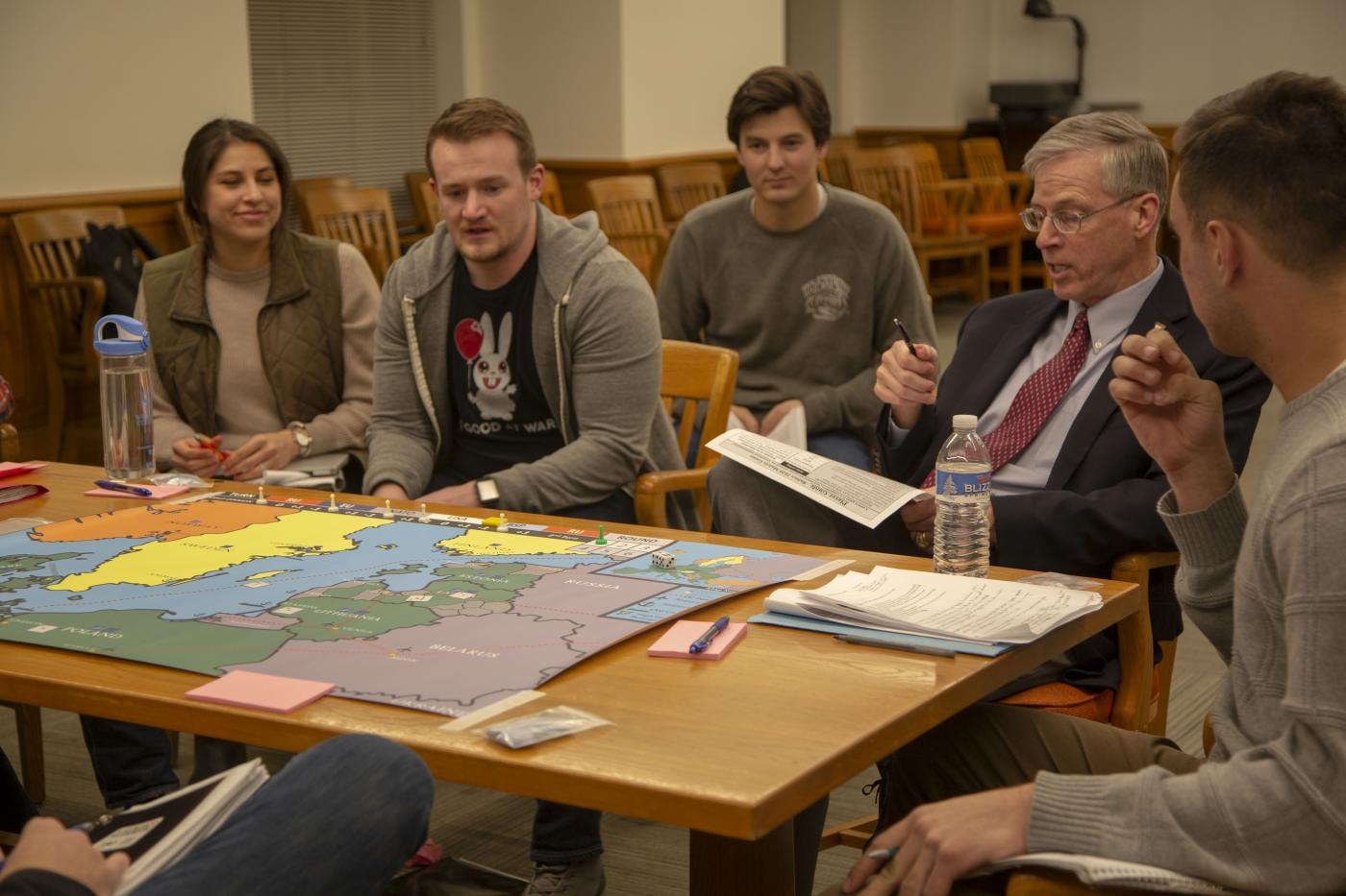 Kevin Weddle discussing military history with students around a table